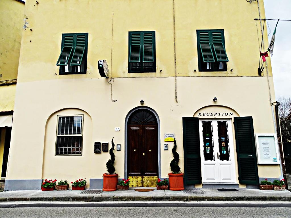 ルッカにあるAffittacamere Arancioの黒いシャッター付きの窓とドアのある建物