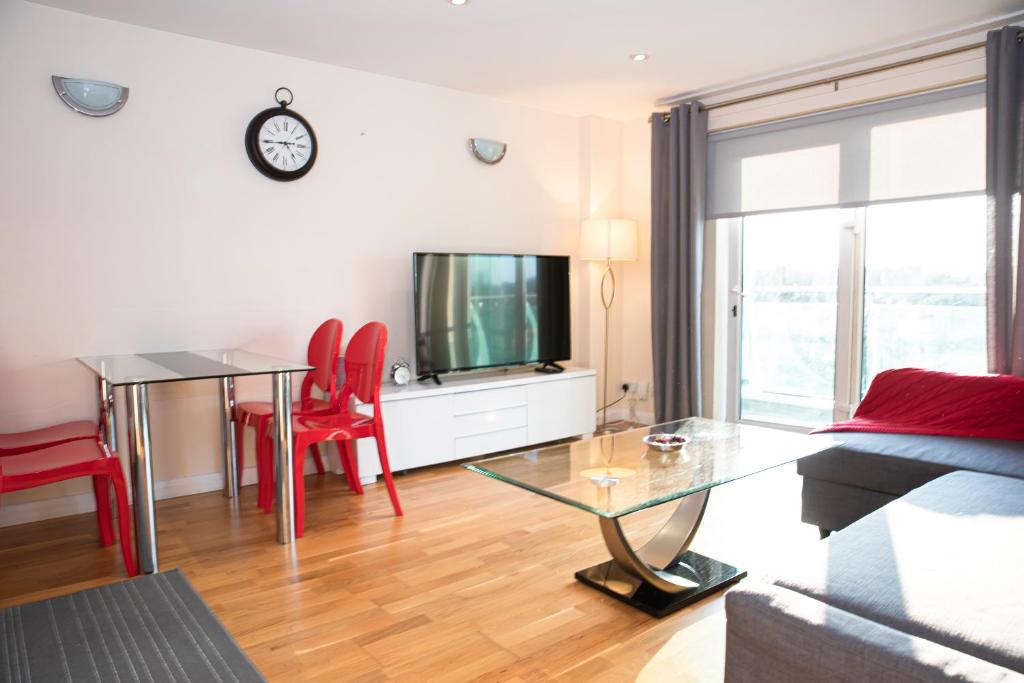 ein Wohnzimmer mit einem Tisch und einem TV in der Unterkunft Tranquil Apartment with Stunning Views in Enfield