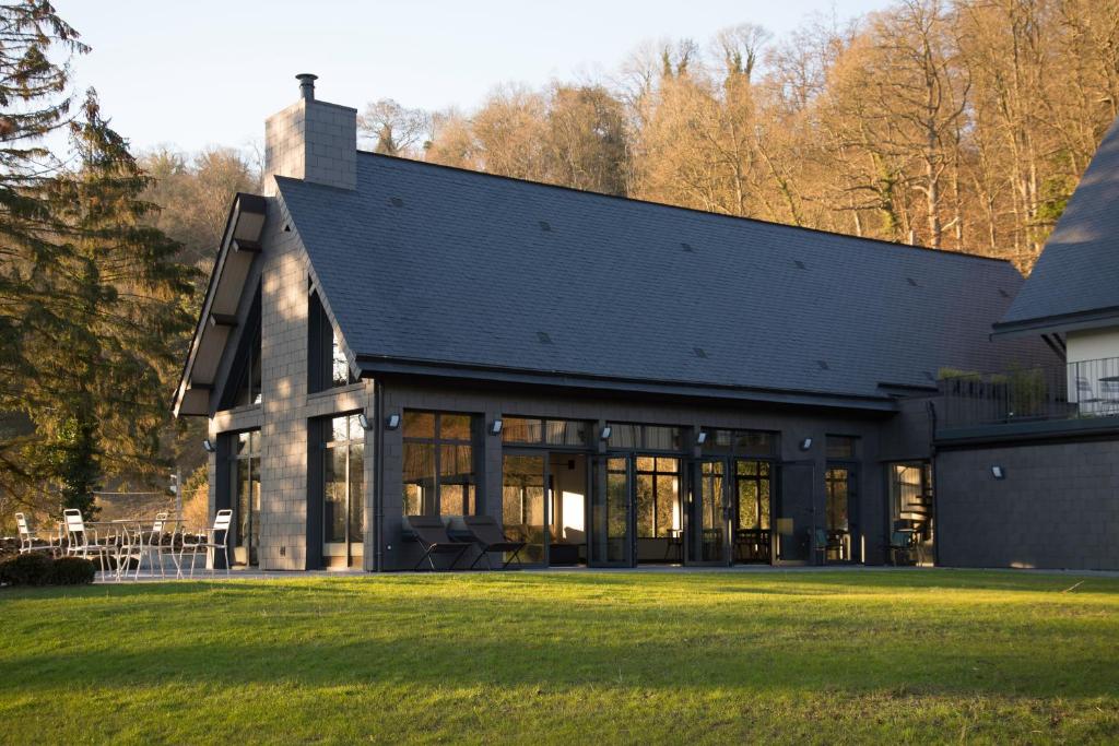 uma casa com um telhado preto num relvado em Les Sources du Val em Saint-Pierre-du-Val