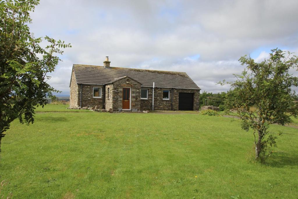 an old stone house in a field of grass at Taigh An Clachair in Lybster