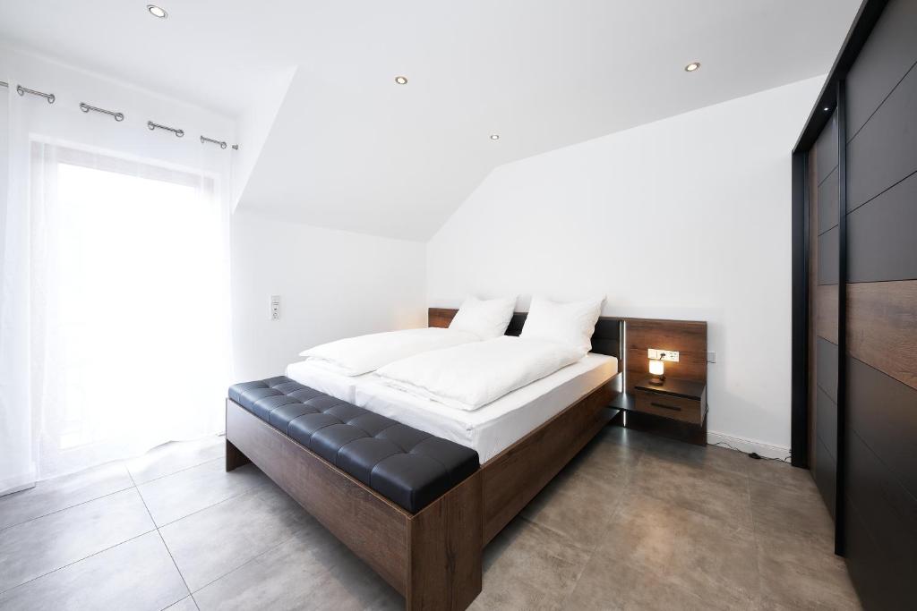 a bedroom with a bed with a black leather seat at Wein Ferienhaus Kerner in Lieser