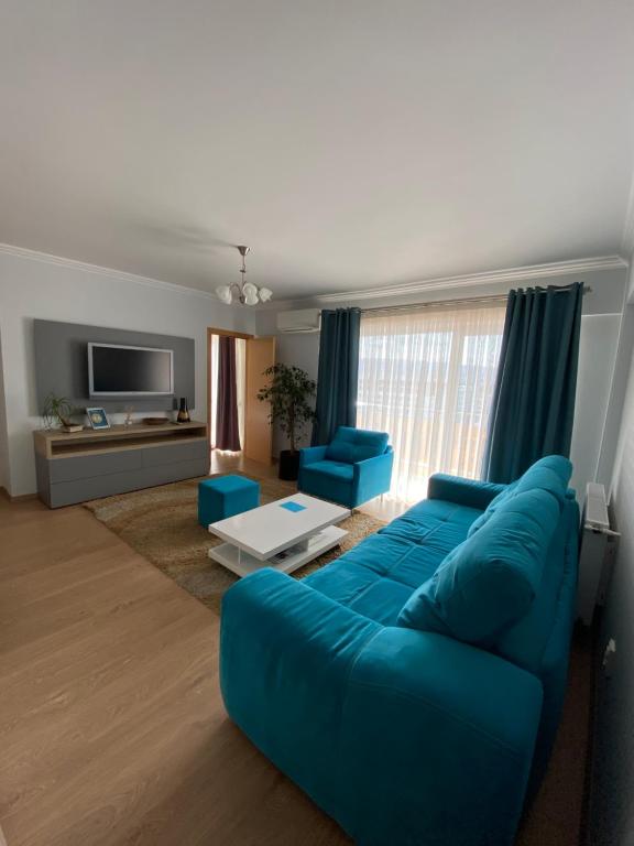 sala de estar con sofá azul y sillas azules en Dora City Apartament, en Cluj-Napoca