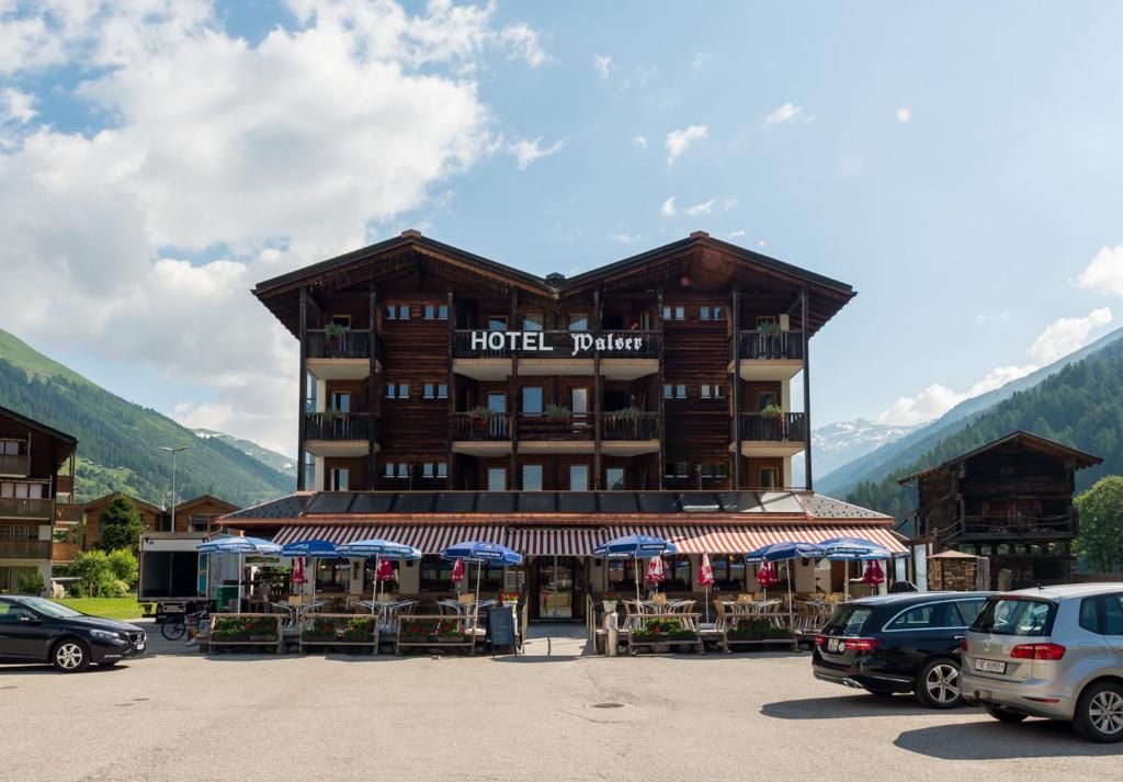 a hotel with cars parked in a parking lot at Hotel Walser in Ulrichen