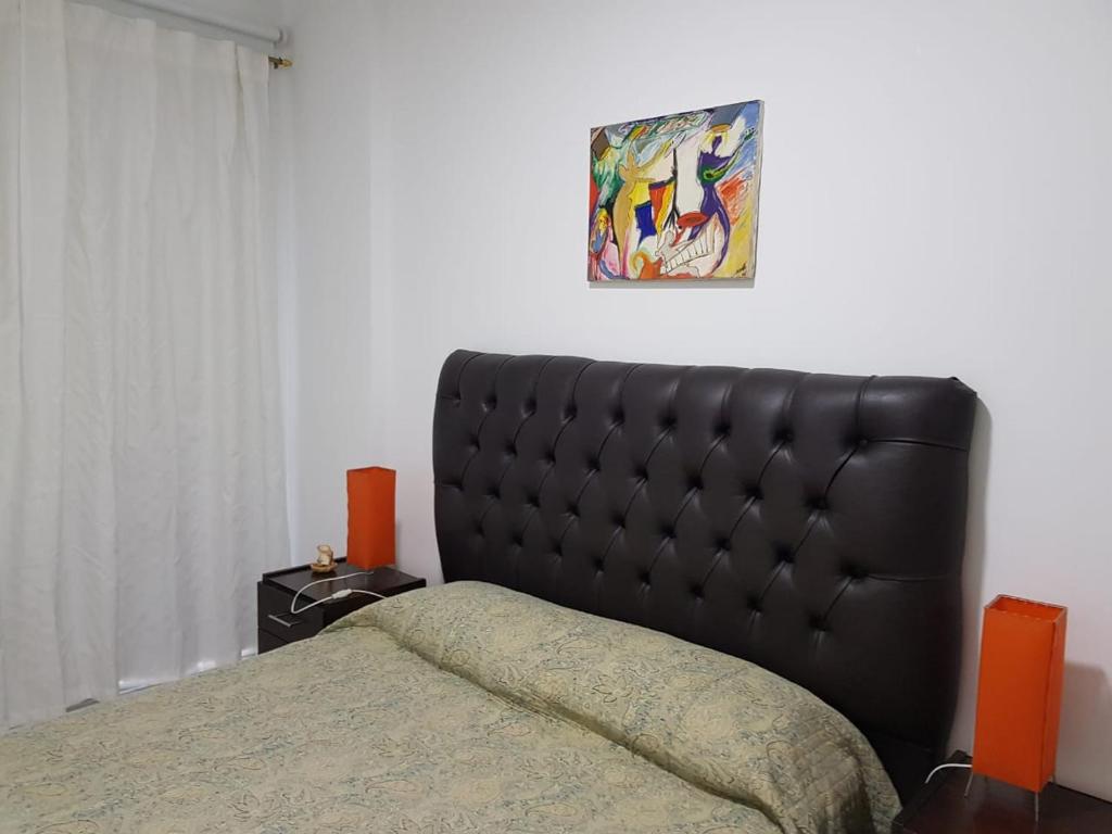1 cama con cabecero negro en un dormitorio en INES en Buenos Aires