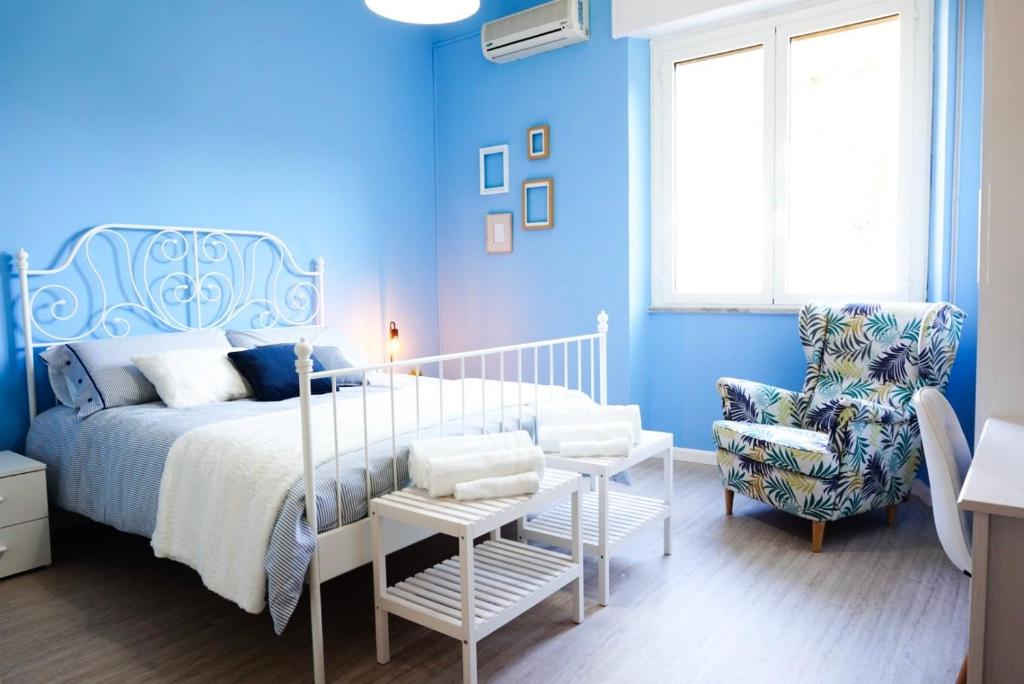 - une chambre bleue avec un lit et une chaise dans l'établissement Villa Aurelia - Seafront Apartment with Terrace, à Flumini di Quartu