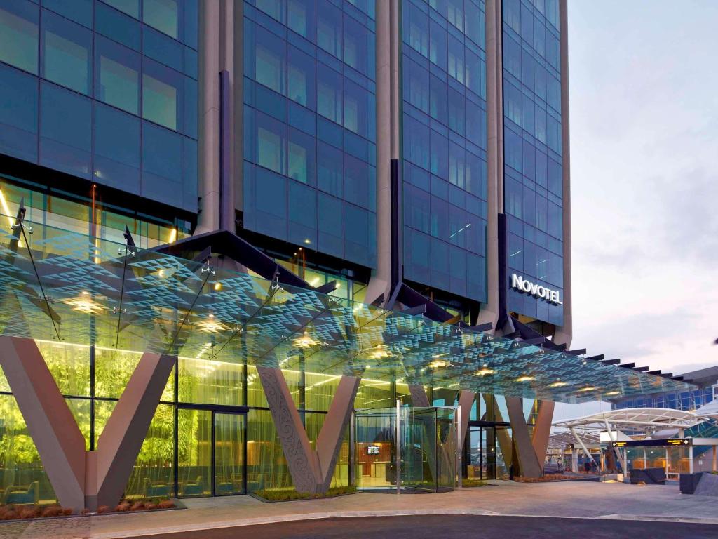 un grande edificio in vetro con un cartello sopra di Novotel Auckland Airport ad Auckland