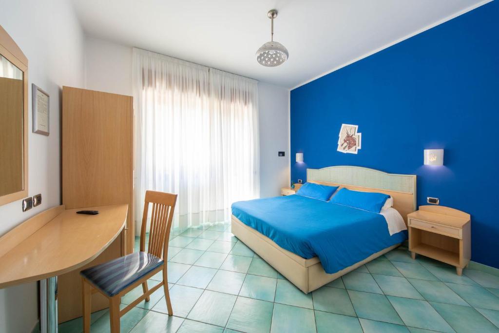 um quarto azul com uma cama e uma secretária em La Casa Delle Stelle em Maiori