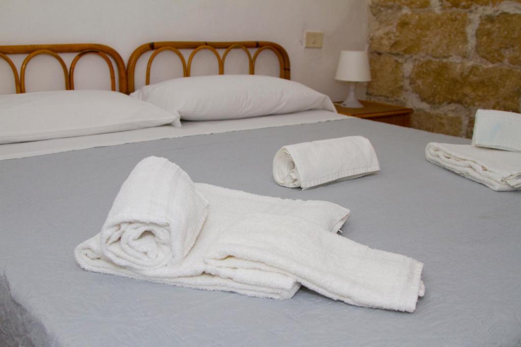 Una cama con dos toallas blancas. en Terrasini 2000 Case Vacanza, en Terrasini