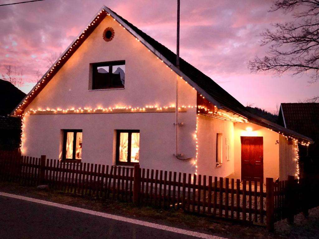 Nezdice na Šumavě 103 في Nezdice: بيت أبيض عليه أضواء عيد الميلاد