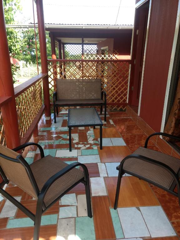 a screened porch with two chairs and a table at Cabañas Pakaia in Hanga Roa