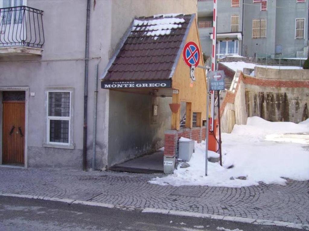 un edificio con un cartello nella neve vicino a una strada di Montegreco Apartment a Rivisondoli