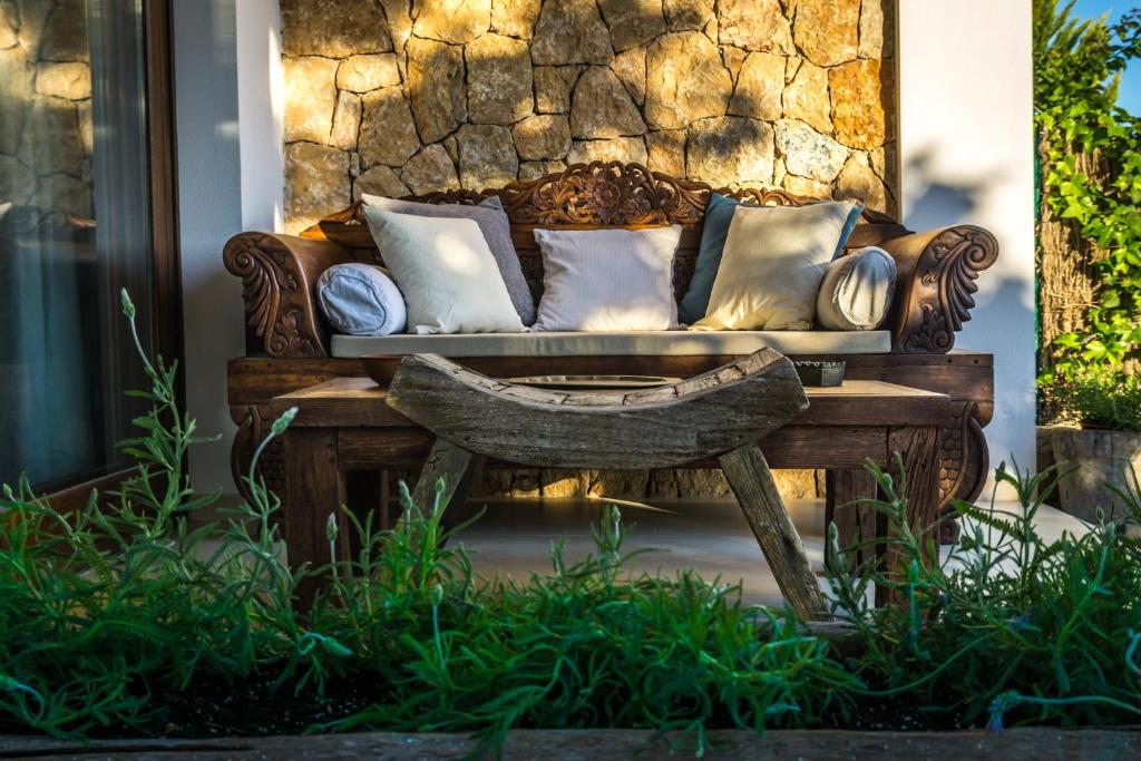 un sofá sentado en un porche con una mesa de madera en Can Olivo - Acogedora casa con exclusivo diseño interior en Ibiza