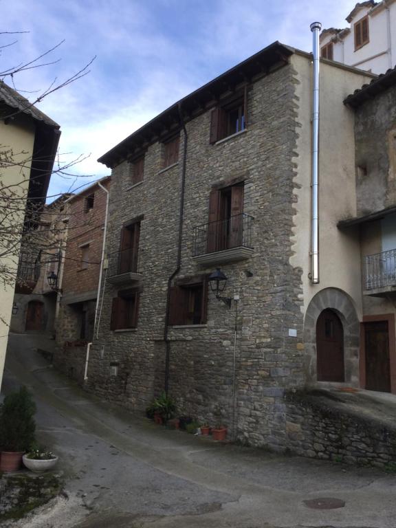 un antiguo edificio de ladrillo con ventanas en una calle en Casa Carbonero, en Lascuarre