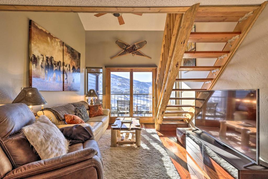 a living room with a couch and a staircase at Steamboat Ski Getaway with Balcony and Resort Views! in Steamboat Springs