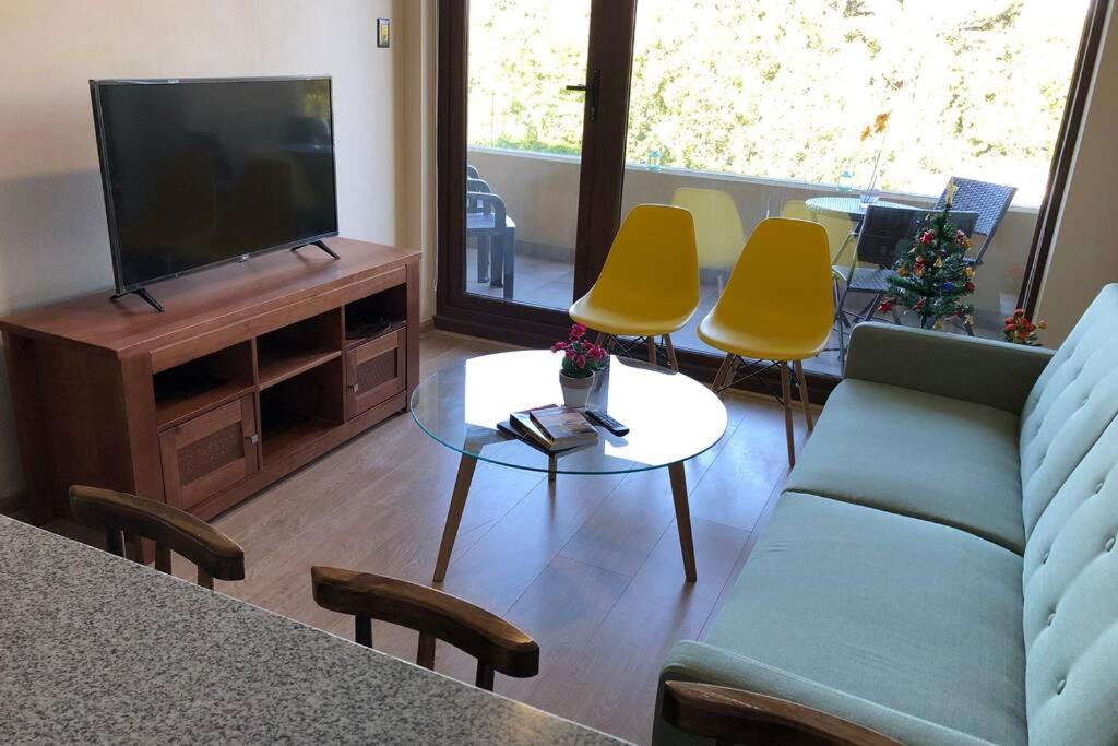 uma sala de estar com um sofá e cadeiras e uma televisão em Departamento en Edificio Costanera Playa Villarrica em Villarrica