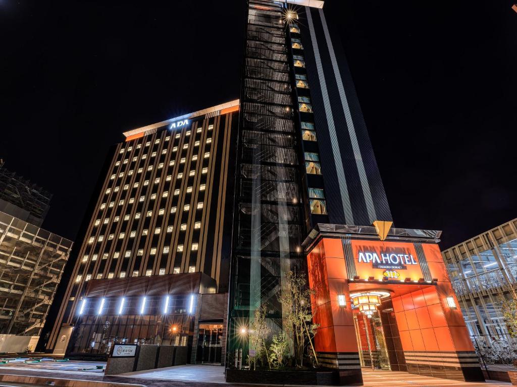 um edifício alto com um sinal em frente em APA Hotel Takaoka Ekimae em Takaoka