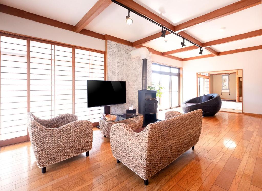 salon z krzesłami i telewizorem z płaskim ekranem w obiekcie Bettei Gensen-Private Vacation Villa Bettei Gensen w mieście Yufu