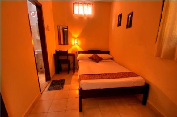 a small bedroom with two beds in a room at Andrea Hotel in Yogyakarta