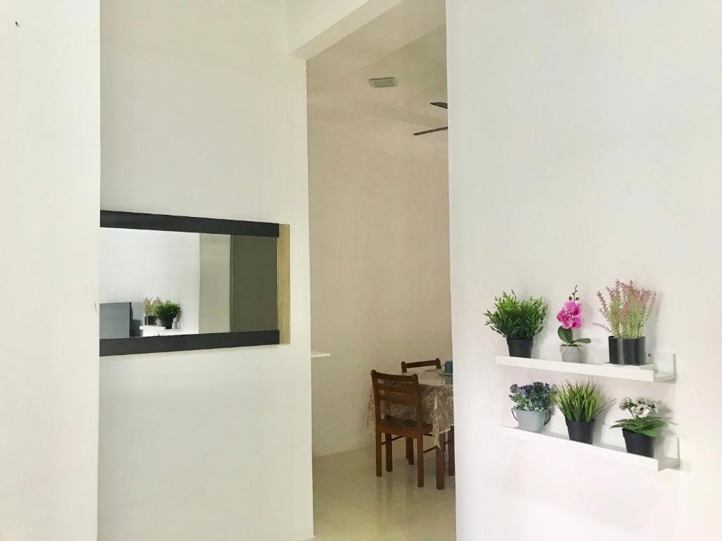 波德申的住宿－HnR HOMESTAY PORT DICKSON，一间客厅,配有镜子和盆栽植物