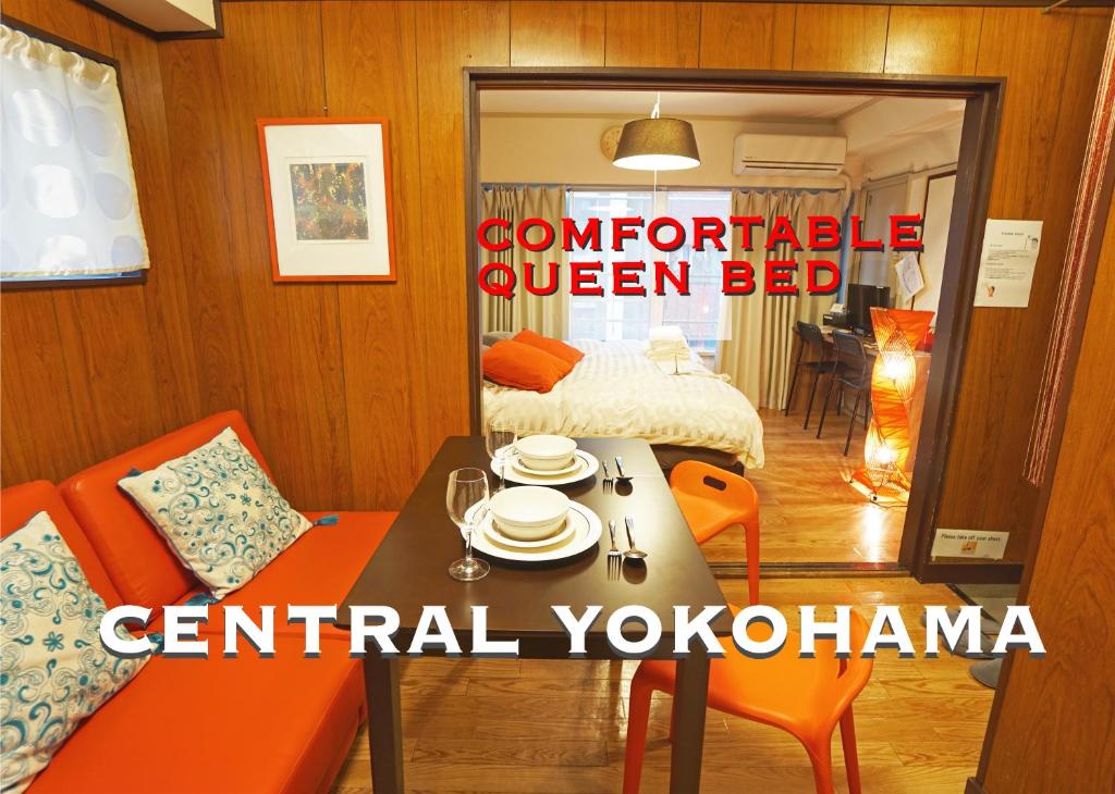 横浜市にある横浜クラシック・アパートメントのテーブル、椅子、ベッドが備わる客室です。