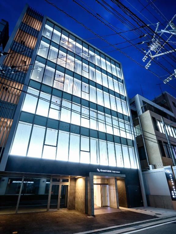 un edificio alto con muchas ventanas en Grand Cabin Tenjin Minami, en Fukuoka