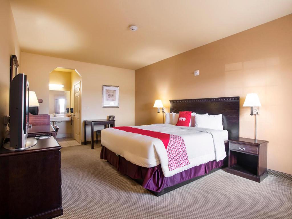 a hotel room with a bed and a flat screen tv at OYO Hotel Valley View TX, I-35 in Valley View