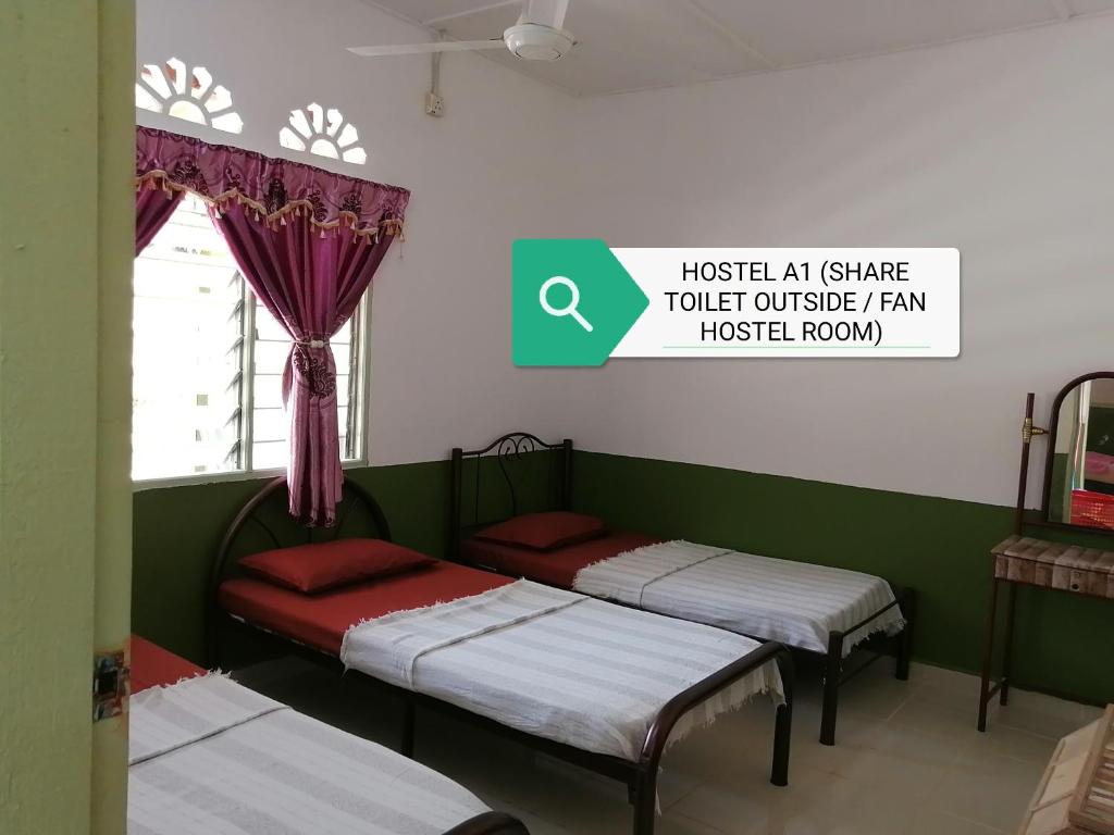 2 camas en una habitación con un cartel que lee albergue y todos comparten el aseo exterior en Delimah guesthouse, en Kuala Tahan