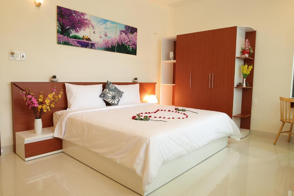a bedroom with a white bed with flowers on it at Lam Garden Boutique Homestay in Hue