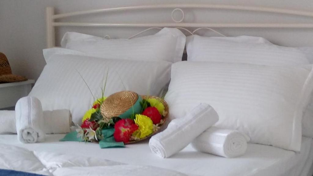 Joy Apartment في كيراموتي: سرير ابيض عليه فواكه