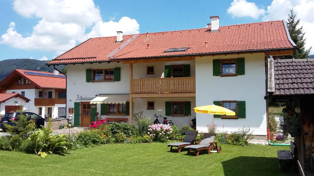 ein großes weißes Haus mit rotem Dach in der Unterkunft Gästehaus Attenhauser in Unterammergau