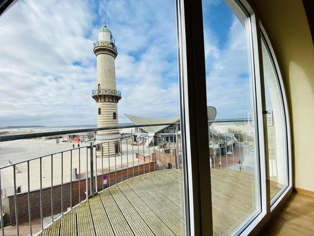 a view of a lighthouse from a window at Sonnendeck, direkt am Leuchtturm in Warnemünde