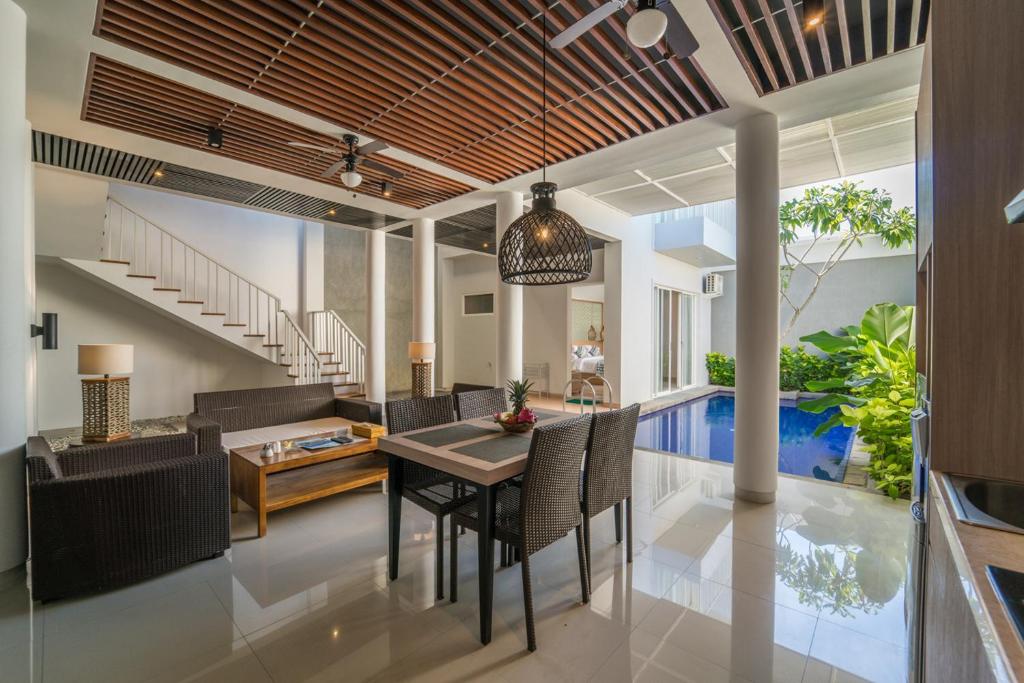 a dining room and living room with a table and chairs at Ola Villas at Uluwatu Pecatu in Uluwatu