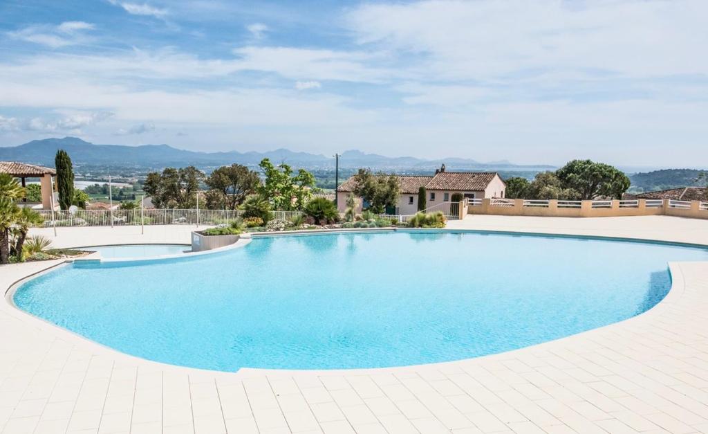 duży błękitny basen na dziedzińcu w obiekcie Appartement 12 - Golf de Roquebrune - Vue mer imprenable ! w mieście Roquebrune-sur Argens