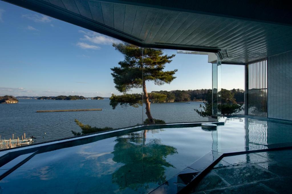 uma casa com uma piscina com vista para a água em Komatsu-kan Kofu-tei em Matsushima