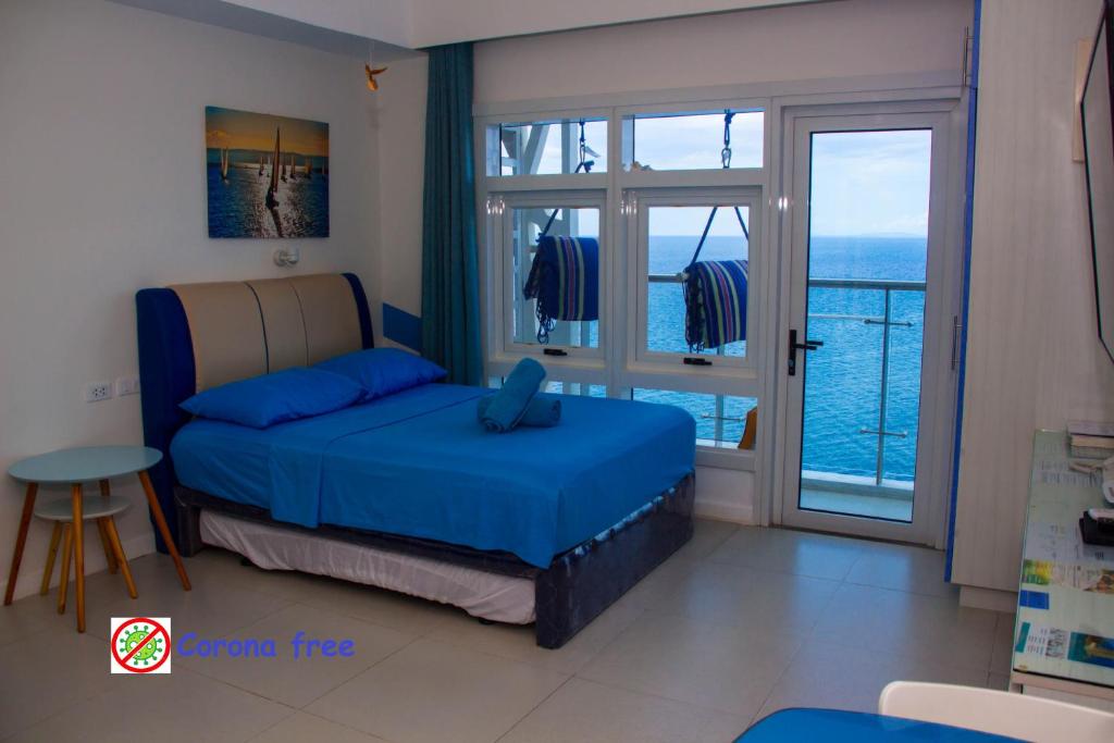 a bedroom with a bed and a view of the ocean at OceanFront at Arterra, fast WiFi, NFlix, kitchen - H or L in Mactan