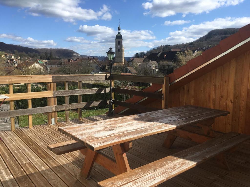 un banc en bois sur une terrasse avec vue dans l'établissement Les terrasses d'Ornans, à Ornans