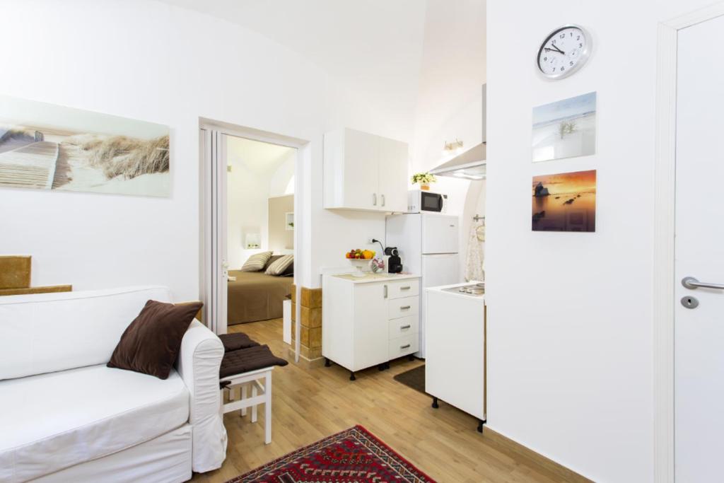 a living room with a white couch and a kitchen at Palermo Central Holiday in Palermo