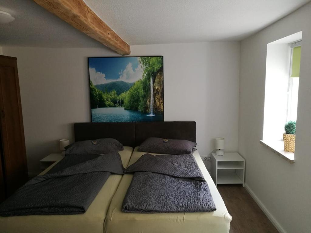 a bedroom with a bed with a picture on the wall at Hainich in Oberdorla