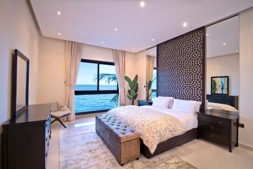a bedroom with a large bed with a view of the ocean at Private 003 - Property Advisers in Dibba