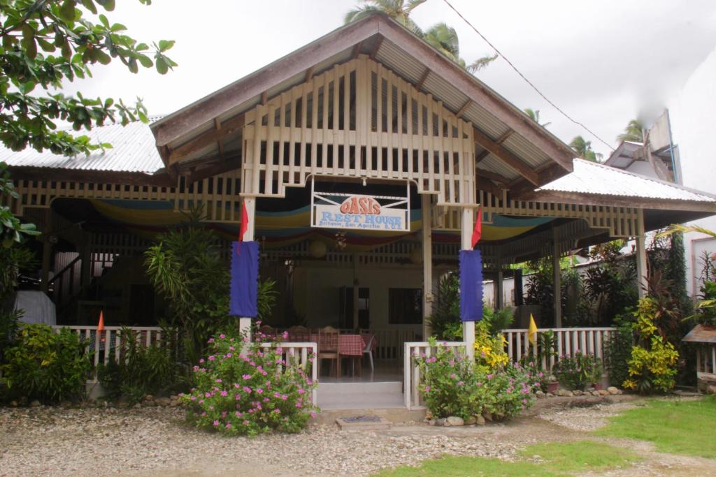 a building with a sign on the front of it at Oasis Resthouse in San Agustin