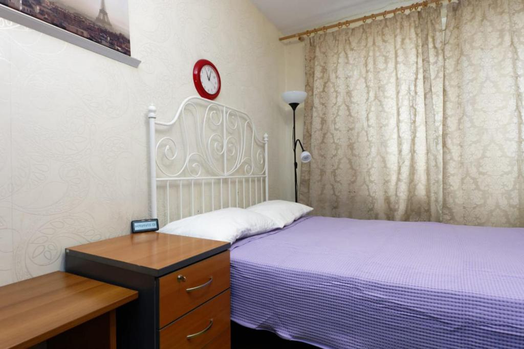 モスクワにあるApartment on Profsoyuznaya 85/1のベッドルーム1室(ベッド1台、壁掛け時計付)