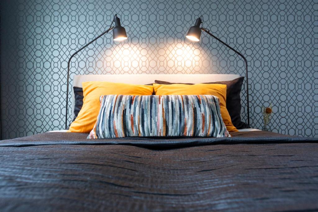 a bedroom with a bed with two lights above it at Vasko luxurious suites, Hilla in Rovaniemi