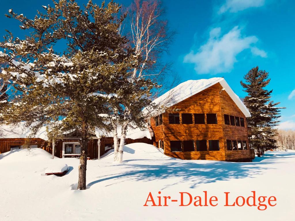 a log cabin in the snow with the words air date lodge at Air-Dale Lodge in Hawk Junction