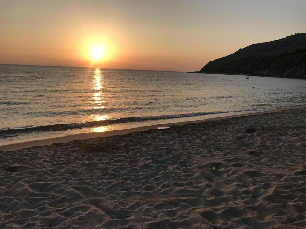 una playa con puesta de sol sobre el agua en House of sea en Nicotera
