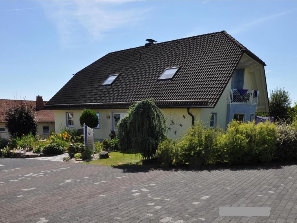 a house with a black roof on a street at Ferienwohnung Zimmermann in Birkenfeld