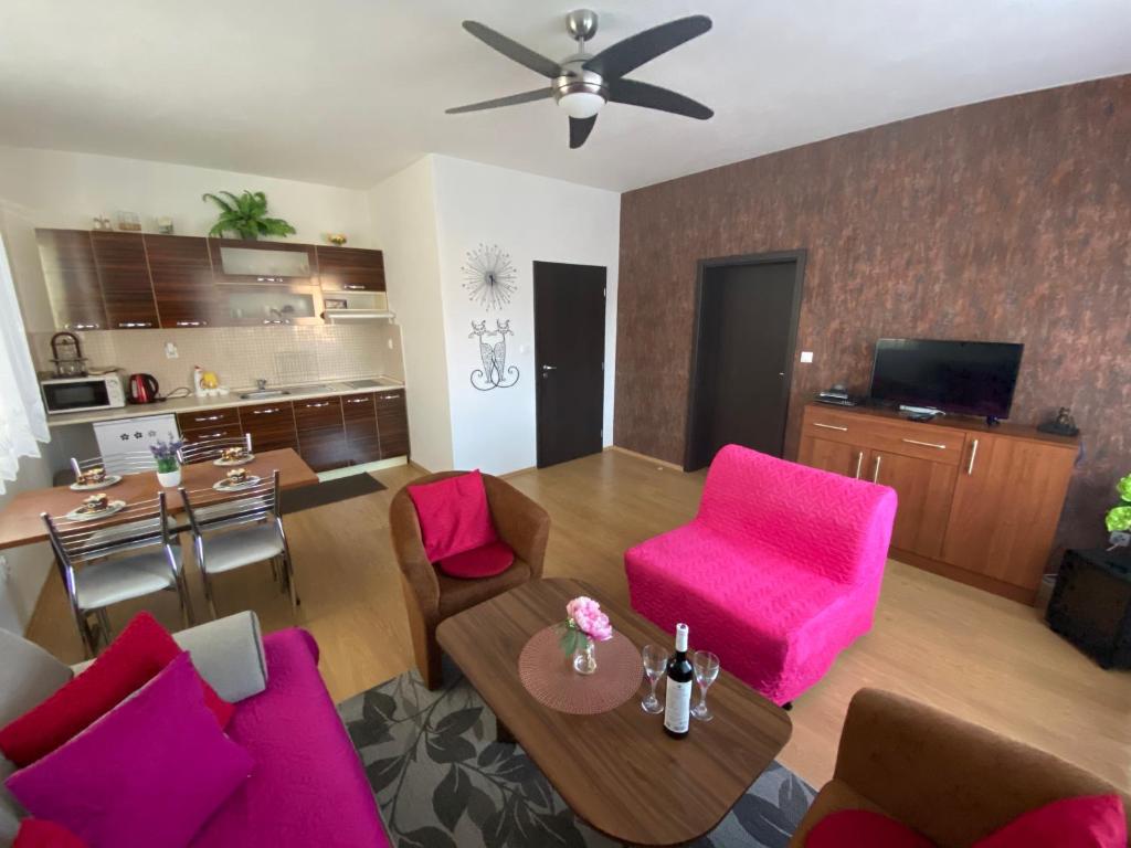 un soggiorno con tavolo e sedie rosa di Apartments Monty Podhájska a Podhájska