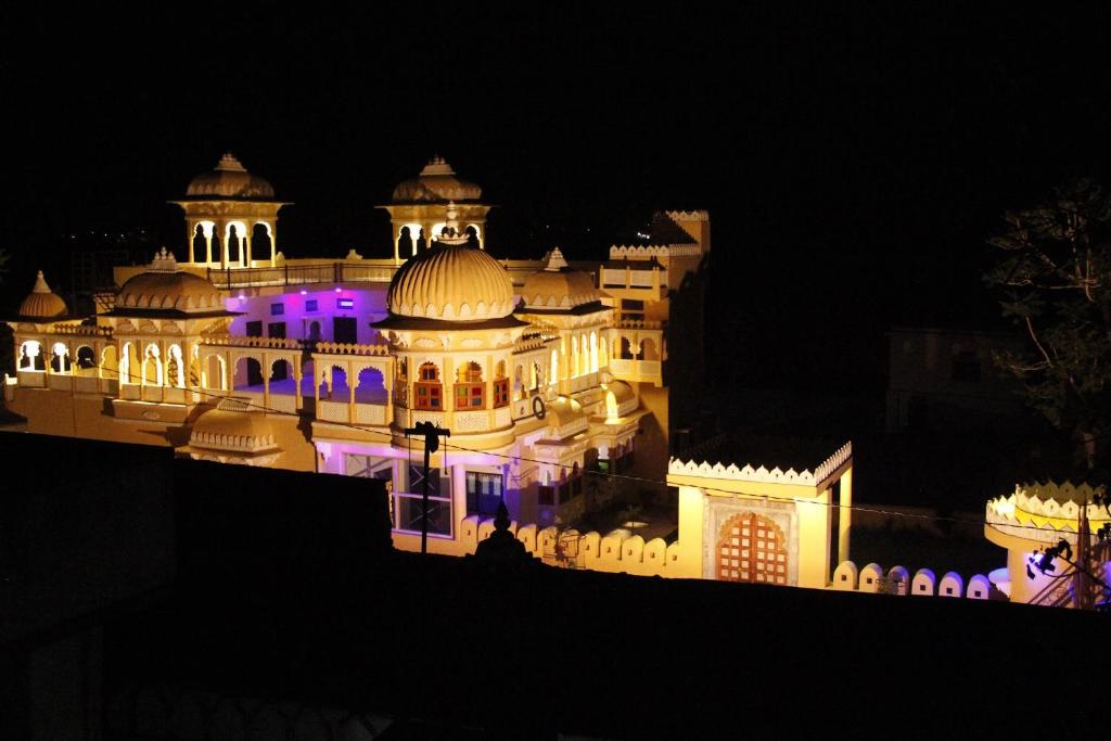 a building lit up at night with purple lights at Deogarh Hills A Village Experience Property in Kaunthal