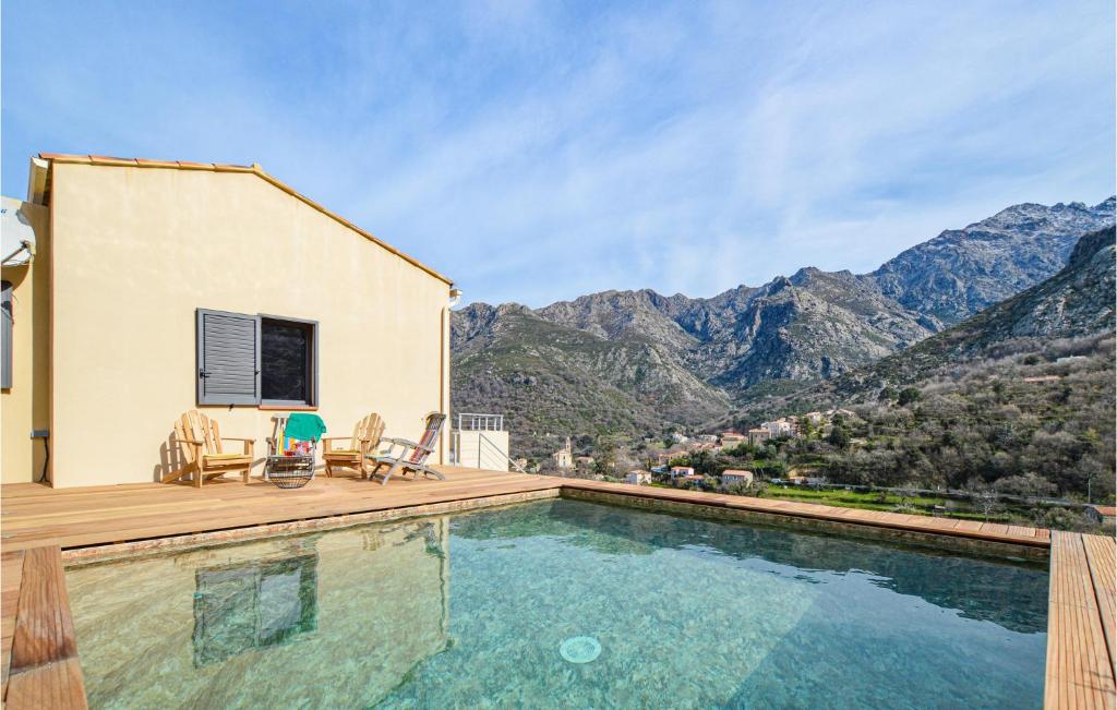 ein Haus mit einem Pool mit Bergen im Hintergrund in der Unterkunft Lovely Home In Feliceto With House A Mountain View in Feliceto