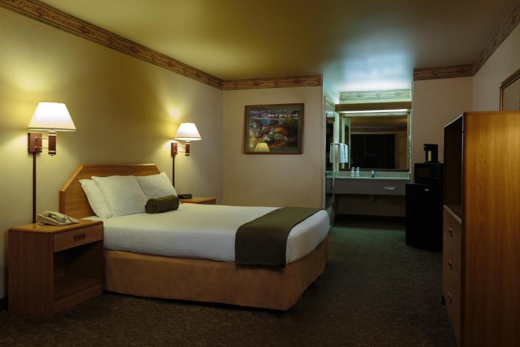 a hotel room with a bed and a bathroom at The Redwood Riverwalk, a boutique hotel in Fortuna