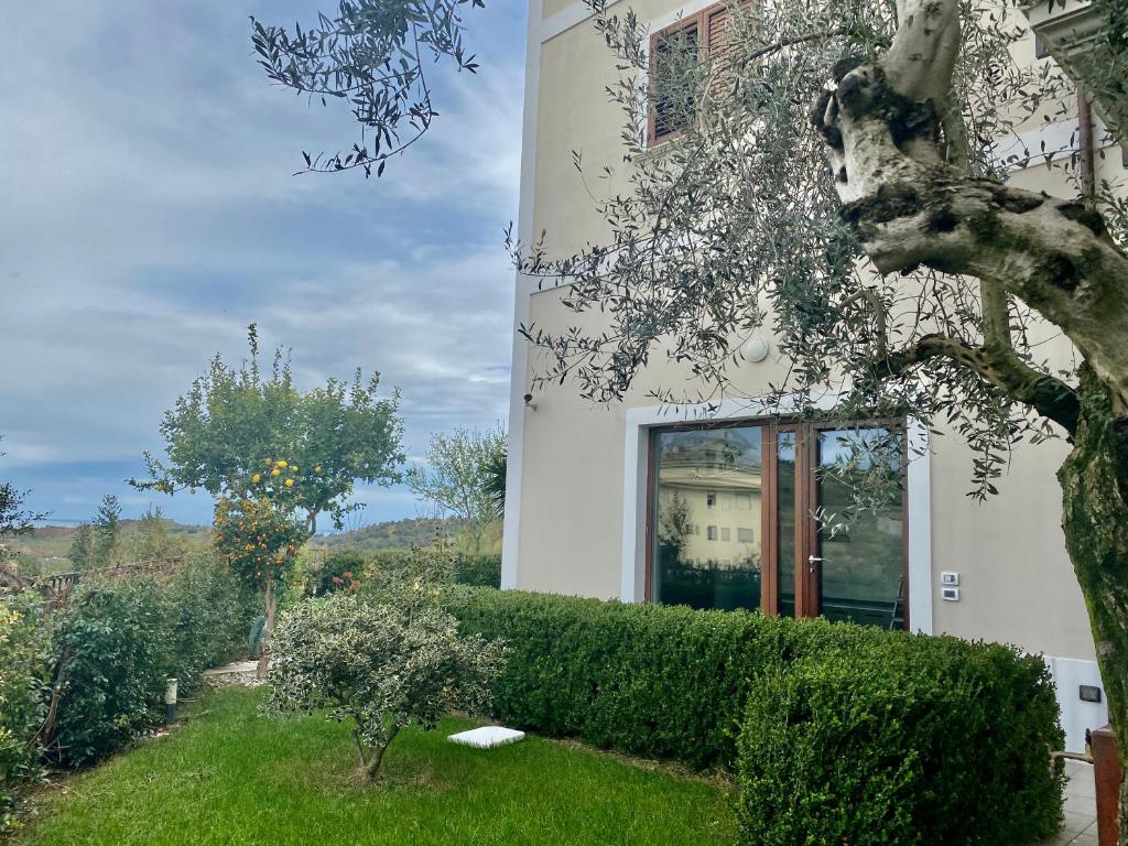 a white house with a hedge in front of it at Villa Torre degli Ulivi in Corigliano Calabro